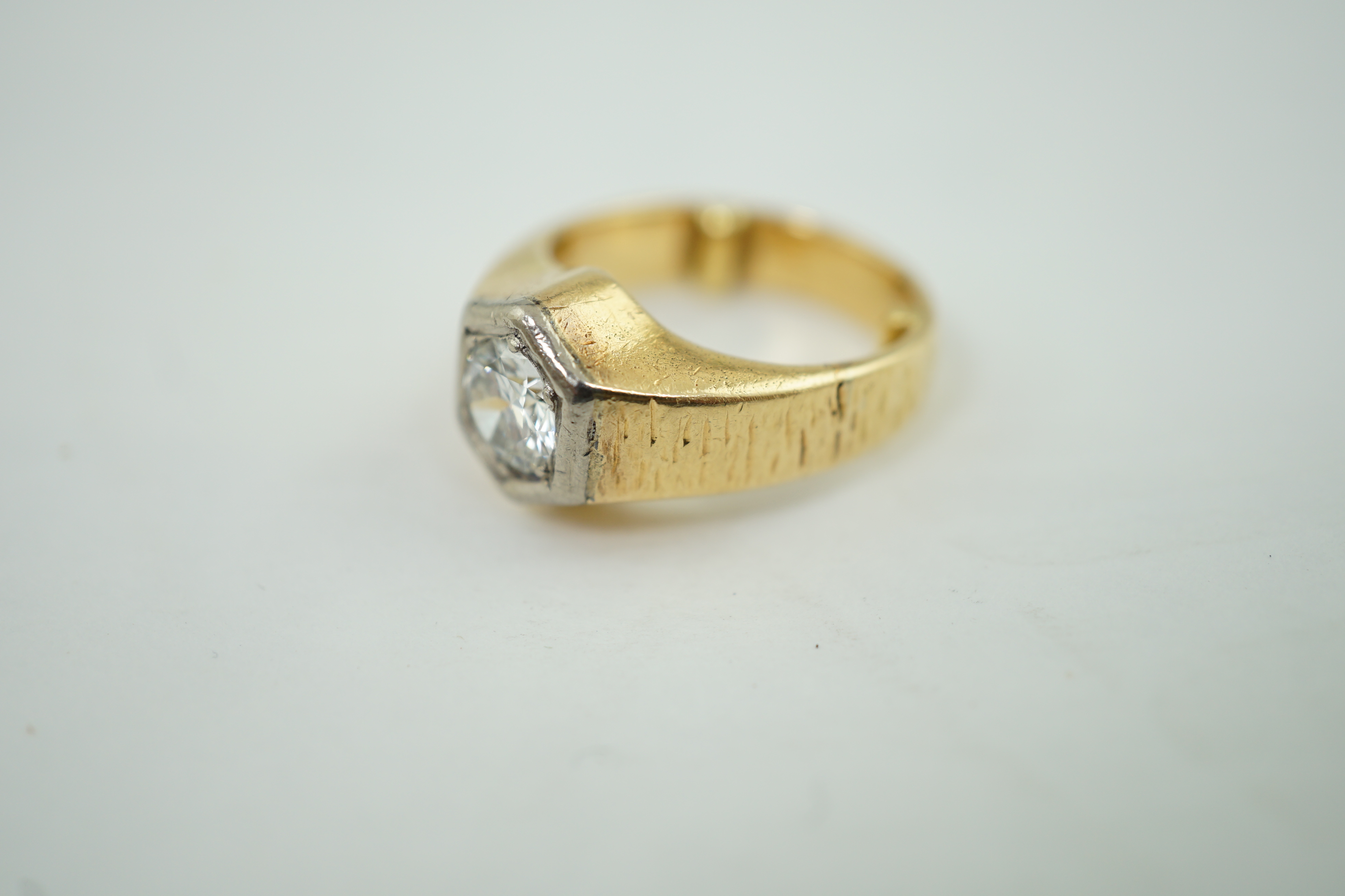 A textured 18ct gold and solitaire diamond set ring